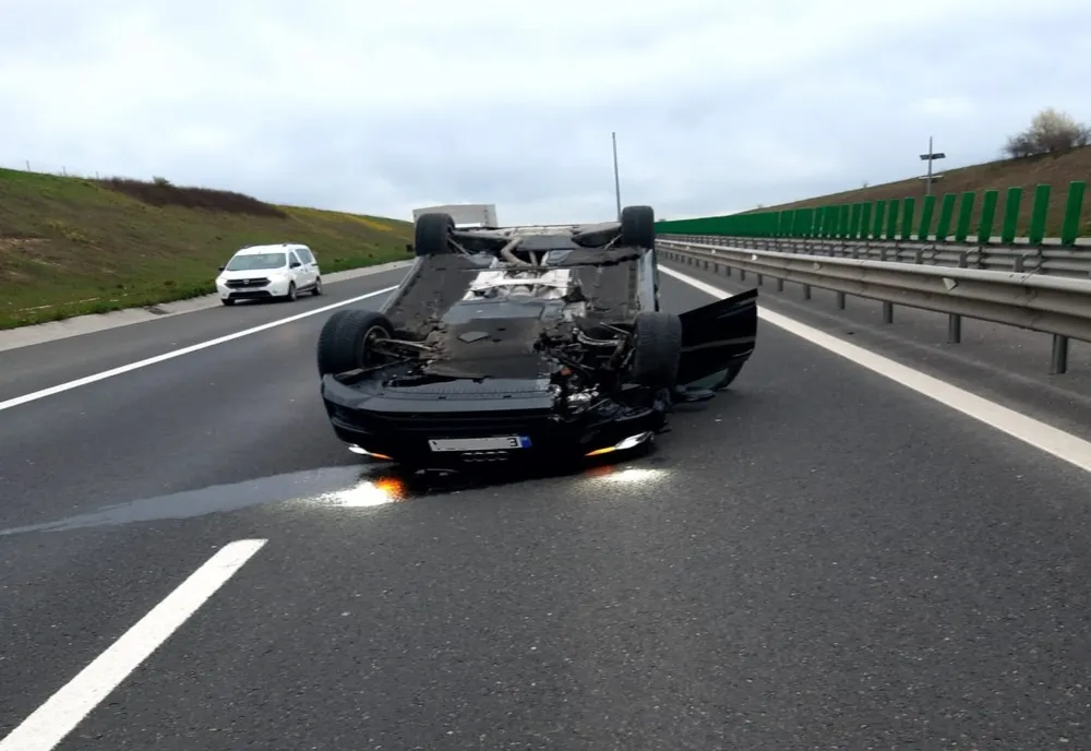 Mașină cu roțile în sus, pe autostradă
