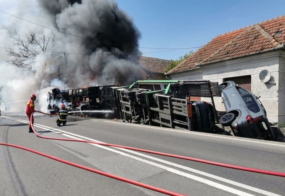 Un TIR s-a răsturnat peste o casă și a luat foc